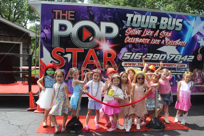 A group of young girls in colorful costumes posing for a photo